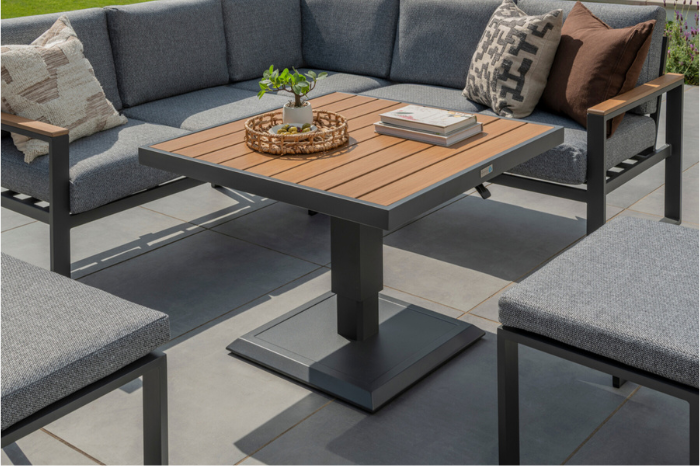 Norfolk Leisure Sutton Mini Corner Set displayed outdoors with height-adjustable Polywood table and grey cushioned modular seating.