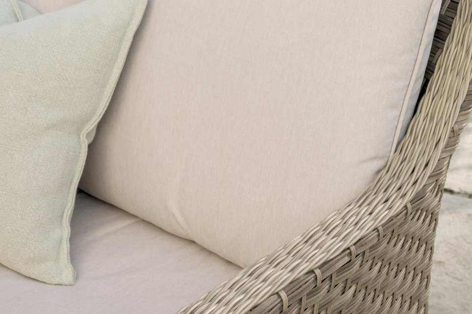 Detail of the Charlbury Signature Corner Set with plush beige cushions and textured rattan frame.
