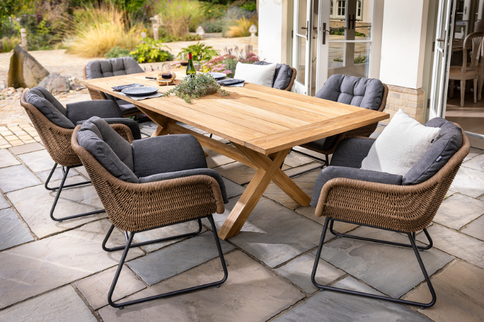 Outdoor teak dining table with six woven dining chairs from the Hartman Rayo range