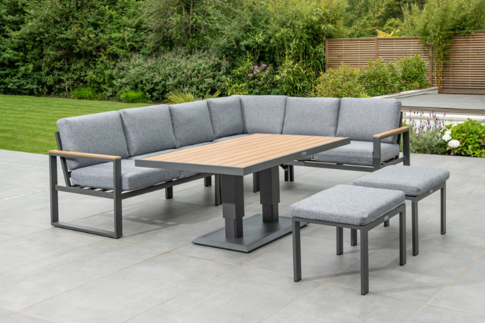 Full view of the Norfolk Leisure Sutton Large Corner Set arranged around the height-adjustable dining table in a garden setting.