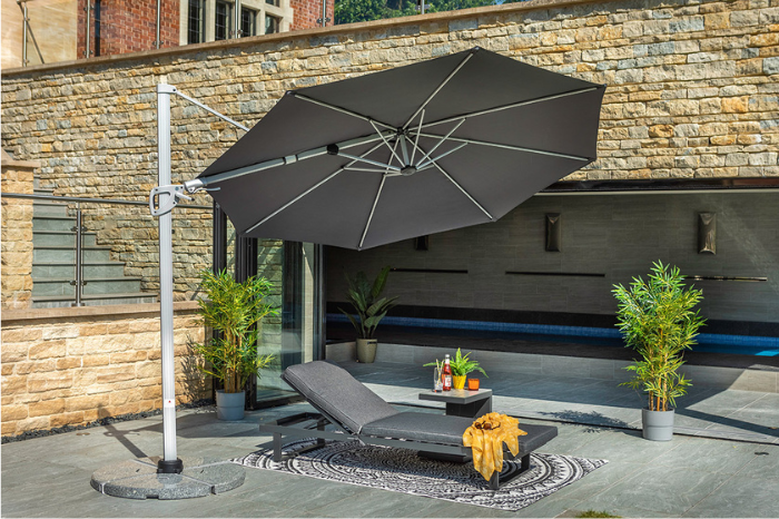 Pacific 3m round cantilever parasol in dark grey providing shade over modern garden lounger