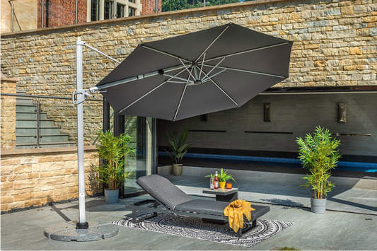 Pacific 3m round cantilever parasol in dark grey providing shade over modern garden lounger