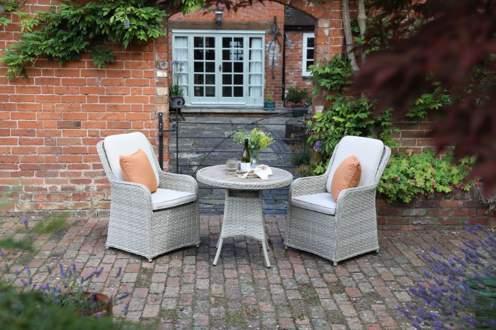 Supremo Hemsby 2 seat round bistro set in a garden setting with soft beige chairs and polywood table