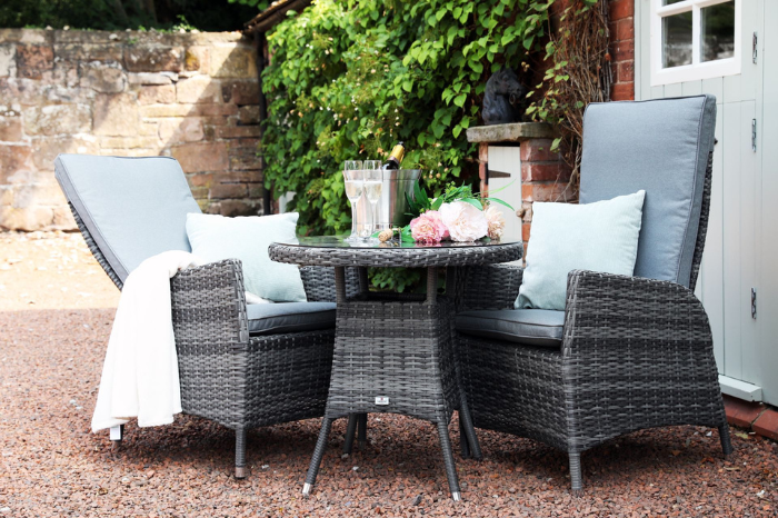 Supremo Tivoli 2 seat reclining bistro set arranged in a garden setting