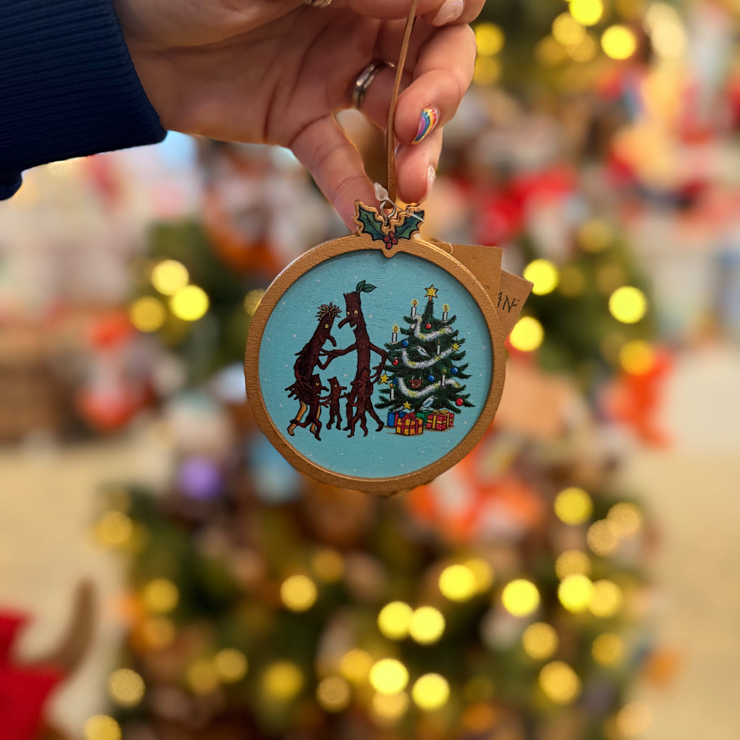 A round wooden Christmas ornament featuring the Stick Man from The Gruffalo